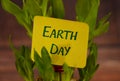 Happy Earth Day text, sign on beautiful green plant.