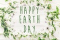 Happy earth day text sign on beautiful lilac and daisy flowers o