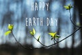 Happy Earth Day text, sign on buds and fresh green leaves on tree branch on blue sky in sunny spring woods. Space for text. Royalty Free Stock Photo