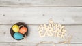 Happy Easer Colorful Easter eggs in the nest on white wooden background. Easter holiday concept, flat lay, top view. Copy space