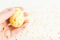 Happy Easter background. Closeup handpainted white egg with gold design in female hand with gold stars on white