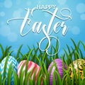 Happy Easter background with colored eggs in the grass on blue sky background Royalty Free Stock Photo
