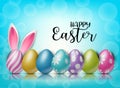 Happy Easter background with painted 3d realistic egg and bunny ears behind on blue backdrop with bokeh. Royalty Free Stock Photo