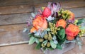 Happy Easter beautiful flower arrangement of coral roses, protea flower, eucalyptus leaves and other plants on wooden