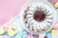 Happy Easter! Big plate with cake and hand painted colorful eggs, tulips on pink background. Royalty Free Stock Photo