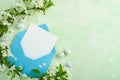 Happy Easter. Blank white paper card in blue envelope, chocolate eggs, fresh cherry or apple blossoms on green background. Spring Royalty Free Stock Photo