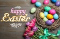 Happy Easter. Bright painted eggs and tulips on wooden table, flat lay