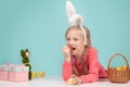 Happy Easter bunny. Child having playing with Easter eggs, eat carrot.