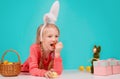 Happy Easter bunny. Child having playing with Easter eggs, eat carrot.