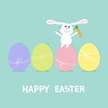 Happy Easter bunny. Rabbit with carrot sitting on painting egg shell set. Painted eggs with thread and bow. Farm animal. Cute cart Royalty Free Stock Photo