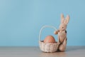 Happy easter, Easter bunny or rabbit or hare doll holds egg with a basket of brown eggs
