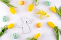 Happy Easter card. Frame with yellow tulips and easter eggs and bunny with copy space for text on white background. Royalty Free Stock Photo