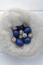Happy easter card - place for text. Blue easter and quail eggs in a snow-white woolen cozy nest on a white wooden Royalty Free Stock Photo