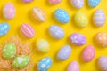 Happy easter celebration holiday. colourful pastel painted eggs in wicker basket nest decoration on a yellow background. Seasonal Royalty Free Stock Photo