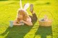 Happy Easter. Child with easter eggs and bunny ears laying on grass. Happy Easter kids face.