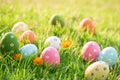 Happy easter!  Closeup Colorful Easter eggs in nest on green grass field during sunset background Royalty Free Stock Photo