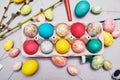 Happy easter. Colored eggs on gray concrete. Flowering, fur-seal willow, on an abstract gray background. Multicolored paints,