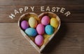 Happy Easter - colored eggs in a heart shaped bowl