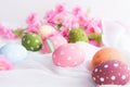 Happy easter! Colorful of Easter eggs in nest with flower and Feather on white cheesecloth background