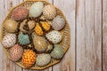 Happy Easter.Colorful hand made Easter eggs with crucifix in wooden basket copy space for text.Spring decoration background. Royalty Free Stock Photo