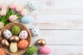 Happy easter! Colourful of Easter eggs in nest with pink tulip flower and Feather on wooden background Royalty Free Stock Photo