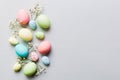 Happy Easter composition. Easter eggs on colored table with gypsophila. Natural dyed colorful eggs background top view