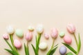 Happy Easter composition. Easter eggs on colored table with yellow Tulips. Natural dyed colorful eggs background top Royalty Free Stock Photo