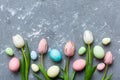 Happy Easter composition. Easter eggs on colored table with yellow Tulips. Natural dyed colorful eggs background top Royalty Free Stock Photo