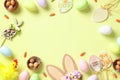 Happy Easter concept. Frame of Easter eggs, rabbit, bunny ears, wooden eggs decorations on green background