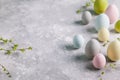 Happy easter concept. Multicolored easter painted eggs and branches with buds on a gray background