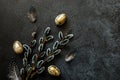 Happy Easter concept. Preparation for holiday. Golden decorated easter eggs willow feather on trendy grunge scratched dark black Royalty Free Stock Photo