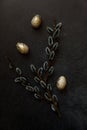 Happy Easter concept. Preparation for holiday. Golden decorated easter eggs willow on trendy grunge scratched dark black shale Royalty Free Stock Photo