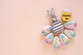 Happy Easter concept with wooden bunny and colorful easter eggs on yellow background