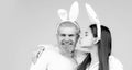 Happy Easter couple kissing, bunny rabbit woman and man hold board paper. Funny Easter bunny couple on blue background