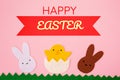 Happy Easter. Cut out the felt applications of white and brown rabbits and the chicken hatched from the egg. Pink Royalty Free Stock Photo