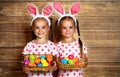 Happy easter! cute twins girls sisters dressed as rabbits with e Royalty Free Stock Photo