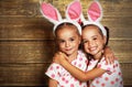 Happy easter! cute twins girls sisters dressed as rabbits on wo