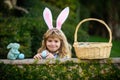 Happy easter day. Child with bunny ears. Child boy hunting easter eggs in backyard.