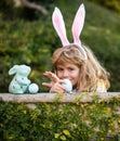 Happy easter day. Child with bunny ears. Children hunting easter eggs. Child with easter eggs and basket and bunny ears