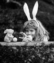 Happy easter day. Child with bunny ears. Children hunting easter eggs. Child with easter eggs and basket and bunny ears
