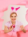 Happy Easter day. Smiling woman in bunny ears painting Easter eggs. Egg hunt. Easter day concept. Happy girl in rabbit