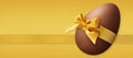 Happy Easter decoration chocolate egg with golden shiny ribbon bow, isolated on gold glitter background. Template for label, gift Royalty Free Stock Photo