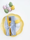 Happy Easter. Easter celebration concept. Top view vertical empty white and yellow plate, Easter eggs, Royalty Free Stock Photo
