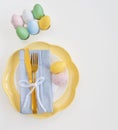 Happy Easter. Easter celebration concept. Top view vertical empty white and yellow plate, Easter eggs, Royalty Free Stock Photo