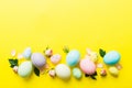 Happy Easter. Easter eggs on colored table with yellow roses. Natural dyed colorful eggs background top view with copy Royalty Free Stock Photo