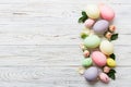 Happy Easter. Easter eggs on colored table with yellow roses. Natural dyed colorful eggs background top view with copy Royalty Free Stock Photo