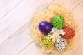 Happy easter. Easter eggs in a nest on a light wooden background, top view Royalty Free Stock Photo