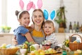 Happy easter! family mother and cheerful children with ears hare getting ready for holiday Royalty Free Stock Photo