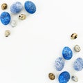 Happy Easter. Frame with blue speckled easter eggs and quail eggs with copy space on white background. Flat lay, top view