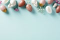 Happy Easter frame made of Easter eggs, bunnies, flowers on light blue background. Flat lay, top view, copy space Royalty Free Stock Photo